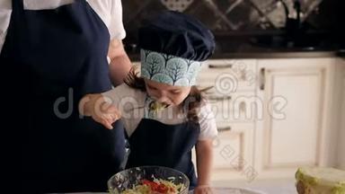 <strong>一个</strong>三岁小女孩用<strong>勺子</strong>吃蔬菜沙拉的特写镜头。